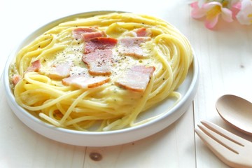 Close up of spaghetti carbonara on white plate.