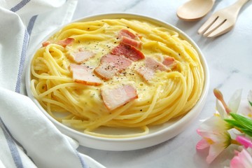 Close up of spaghetti carbonara on white plate.