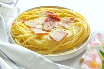 Close up of spaghetti carbonara on white plate.