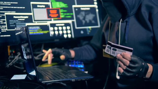 Man hacks information from banking cards, close up.