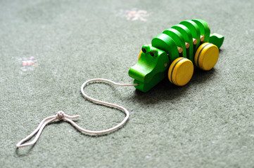 Naklejka premium Small wooden child's toy. Pull along crocodile on wheels