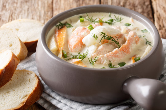 Homemade fish soup with cream, carrots and celery in a bowl close-up filed and bread. horizontal