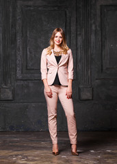 Fototapeta premium Fashion portrait of pretty sexy young blonde woman in pink pantsuit
