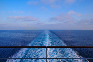Kreuzfahrtschiff auf hoher See mit Kielwasser in Blau