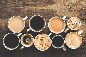 Many cups of coffee on a wooden table. Top view
