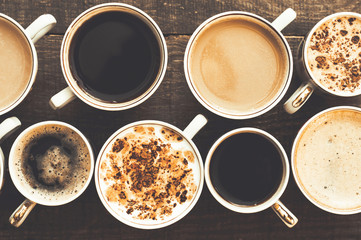 Many cups of coffee on a wooden table. Close. Top view