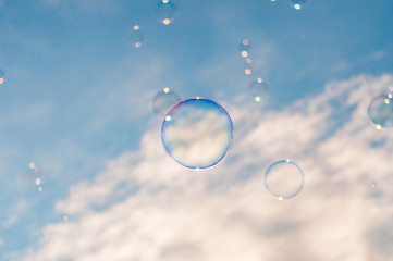 Light and colorful soap bubbles flying with the wind in the air