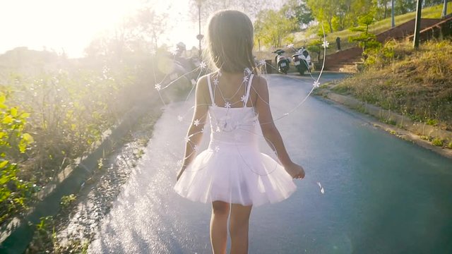 Rear view of a beautiful little girl in a fairy costume