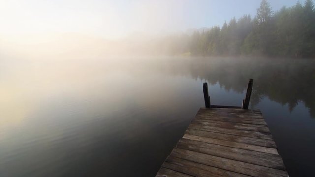 Sonnenaufgang mit nebel am See in den Bergen