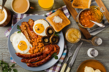 Full English breakfast, with sausage, mushrooms, beans and a fried egg.
