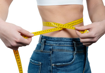 Woman measuring her waist with a yellow measuring tape