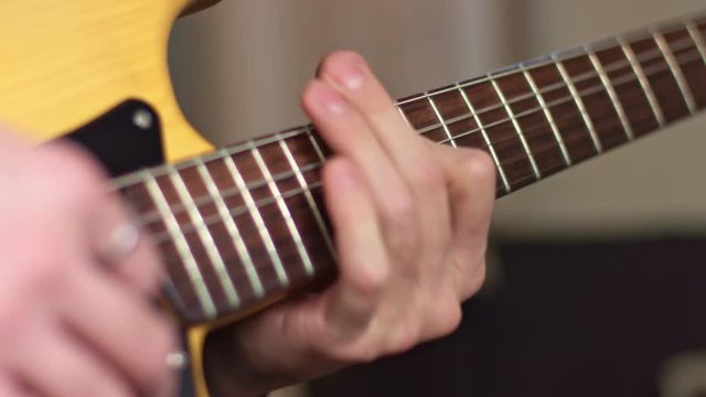 Close up guitarist fingers on fretboard