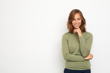 portrait of a young happy woman smiling and thinking on white background looking in camera