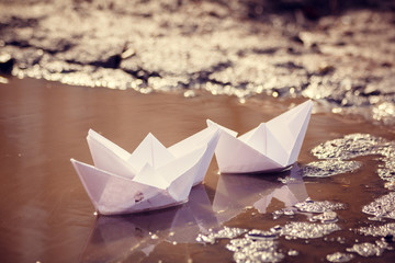 The paper boat floats through the spring puddles. Children's entertainment.