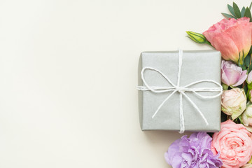 Present delivery. Silver gift box. Festive flower decor. Copy space on ivory background. Top view.