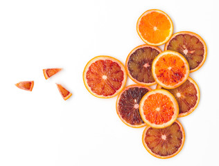 many fresh slices of blood oranges lie beautifully arranged on a white background