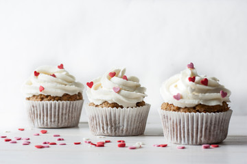 Valentine cupcakes decorated with sweet hearts on wooden table