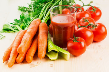 Glass of different vegetable juices with carrots, tomatoes and c