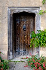 Old wooden front door with large ornate hinges