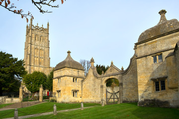 Autumn sunshine on the picturesque church and gatehouses in Chipping Campden, a Cotswolds travel...