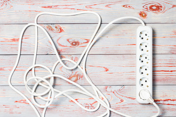 wooden background in retro style, on it is an extension cord with European cuts