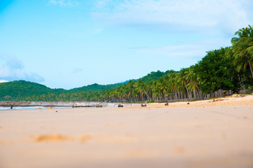 Light waves. Ocean and sand. Summer Islands, blue sky and clouds.