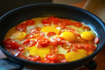 Red sliced ​​tomatoes fried in a pan for cooking scrambled eggs