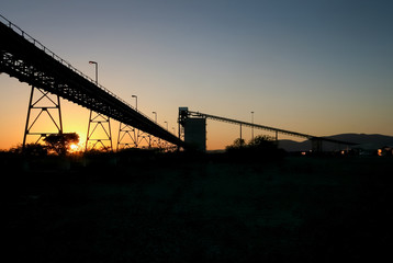 Silhouette of a mining silo and conveyor belts