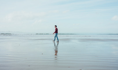 Boy walking on the beach at low tide