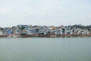 Fototapeta na wymiar Pushkar / India - August 2011: View over the town of Pushkar with the Pushkar lake.