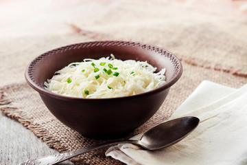 Sauerkraut with green onions in rustic bowl