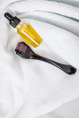 Dermaroller, Handtuch und gelbe Pflege Öl Flasche zum  Microneedling für Anti Aging Lifting oder...
