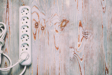 wooden background in retro style, on it is an extension cord with European cuts