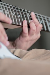 8 year old British Indian boy practicing the guitar at home. 