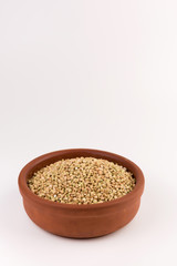 Natural fresh green buckwheat in bowl isolated on white background.