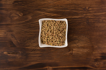 Yellow lentil in a bowl on wooden background