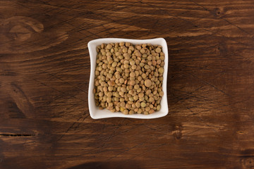 Yellow lentil in a bowl on wooden background