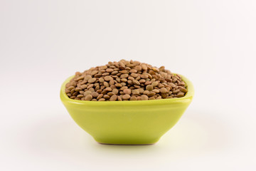 Yellow lentil in a bowl isolated on white background