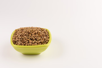 Yellow lentil in a bowl isolated on white background