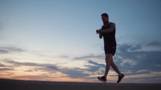 Man jogging alone on shore.