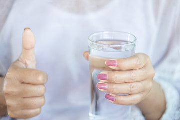 closeup healthy woman hand holding glass of fresh water 