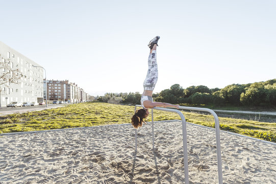 Woman training on parallel bars on street