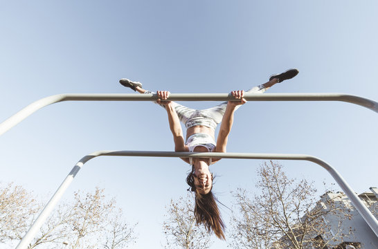 Woman training on parallel bars on street