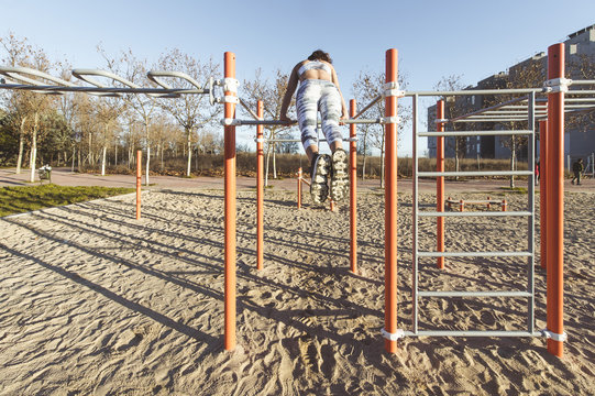 Woman training on parallel bars on street