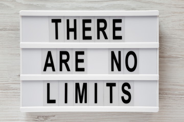 Modern board with text 'There are no limits' on a white wooden background, view from above. Flat lay, overhead.