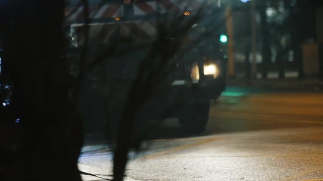 Close-up view of the street sweeper machine cleaning up the fallen leaves in the city at night.