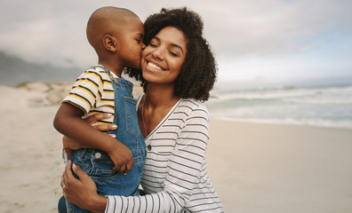 Son kissing his mother at the beach - Powered by Adobe