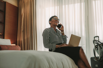 Woman CEO on business trip working from hotel room - obrazy, fototapety, plakaty
