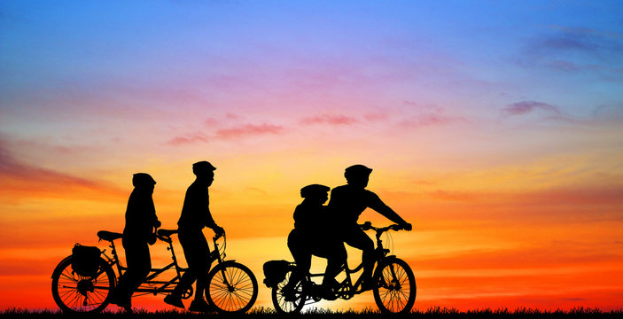 Silhouette group friend  and bike relaxing on blurry sunset background.