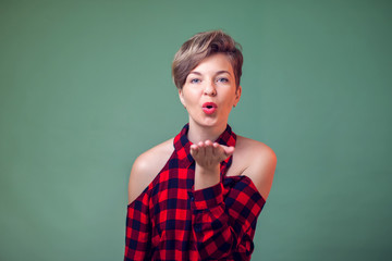 People and emotions - a portrait of happy woman blowing a kiss, looking at camera